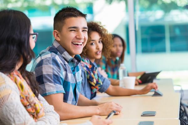 Four smiling students sitting in class