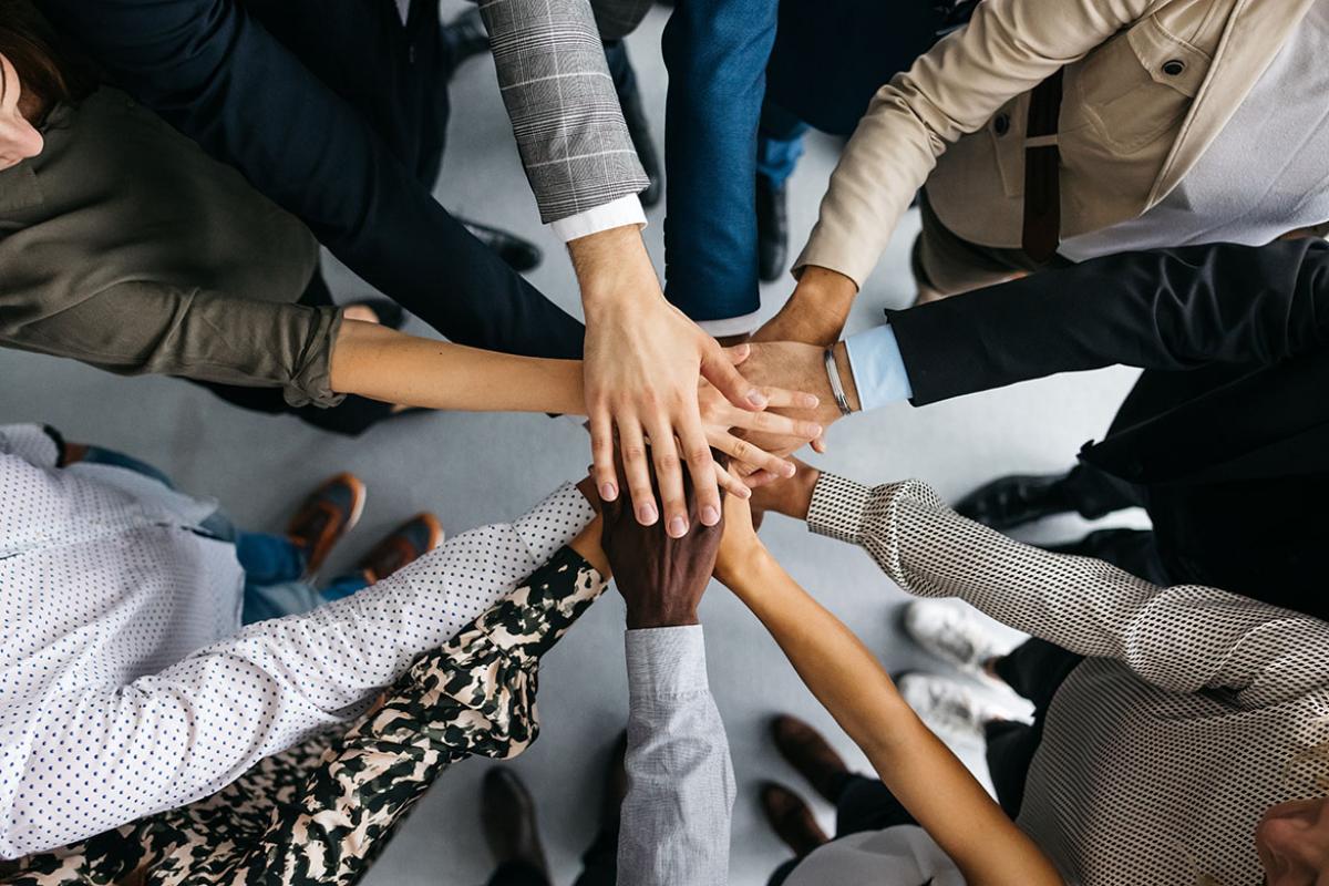 Group in a circle with their hands stacked