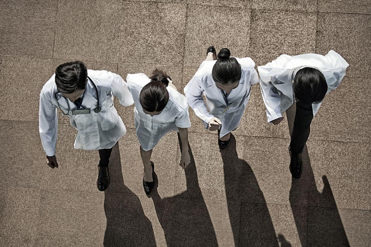 Four health care workers walking in a row