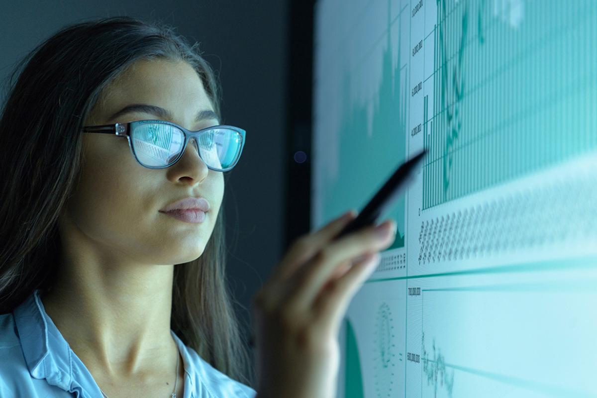 Business person pointing at a computer screen displaying data