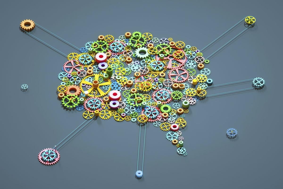 Multi-color gear wheels connected together in shape of brain