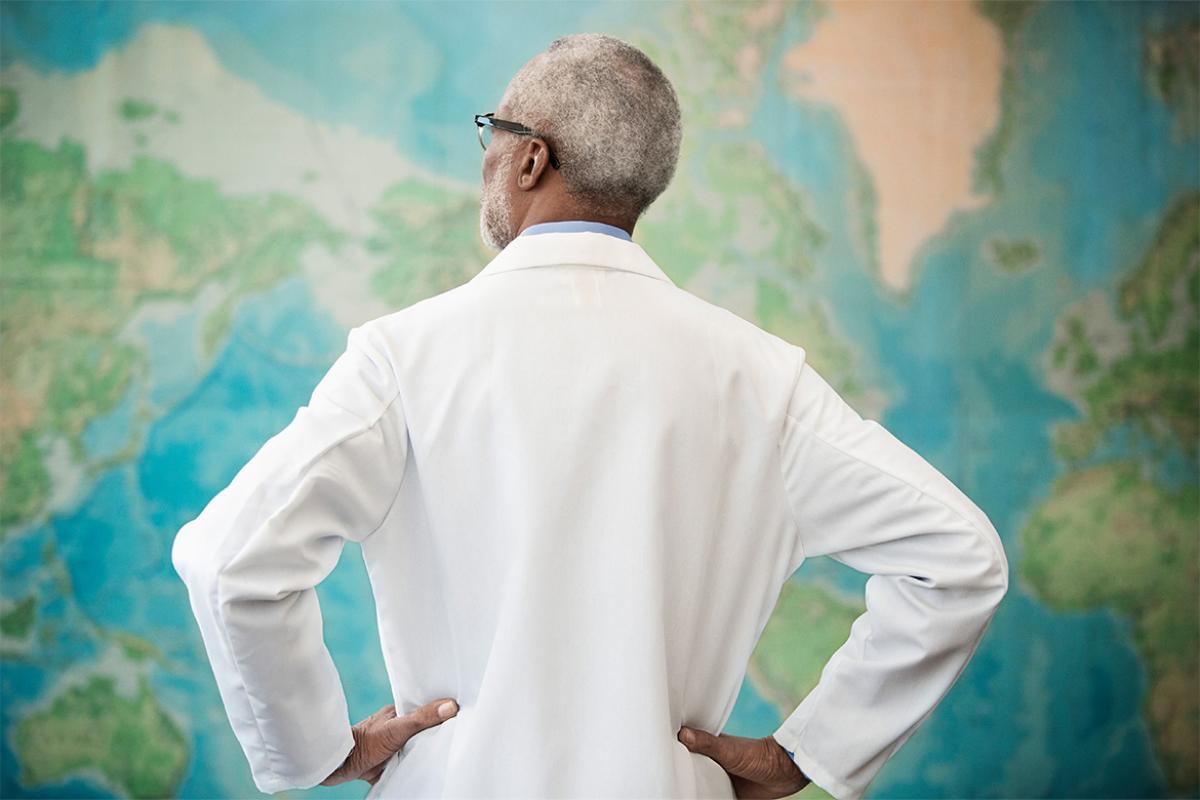 Physician standing in front of a world map