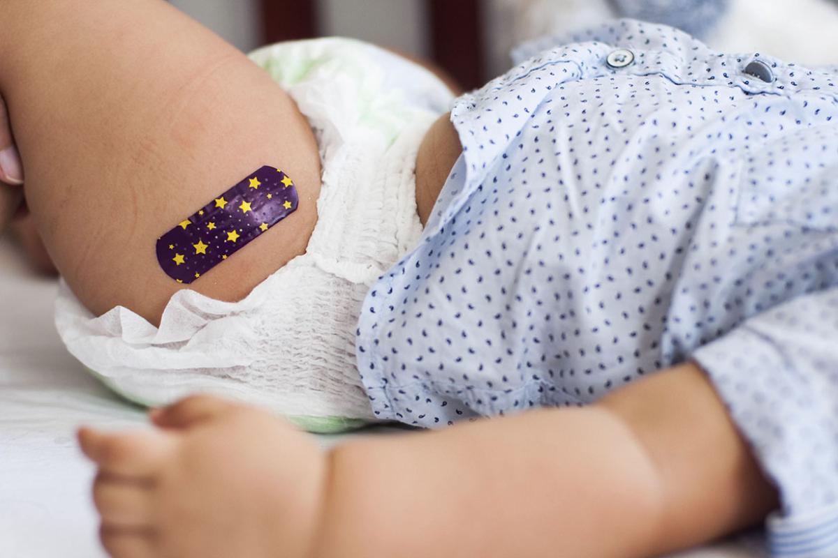 Baby with a bandage after receiving vaccine
