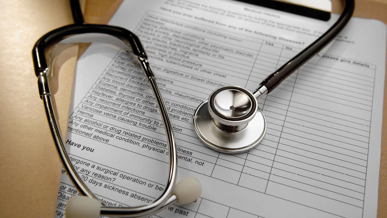 Stethoscope wrapped up on top of a clipboard