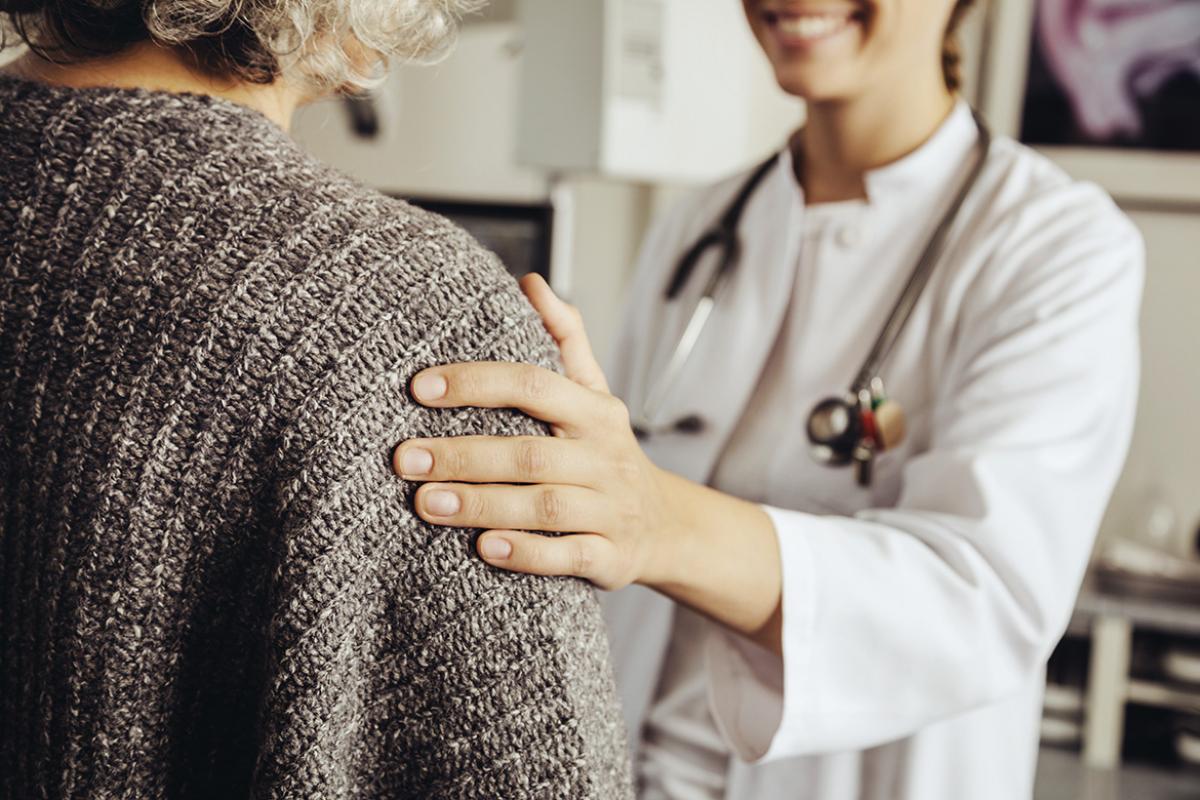 Physician placing a reassuring hand on the shoulder of a patient