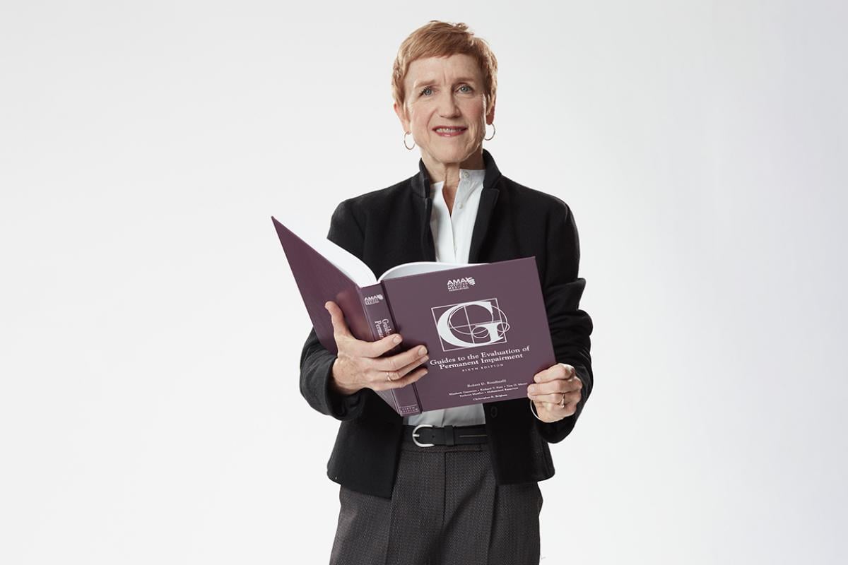 Helene Fearon, PT, holding the AMA Guides book