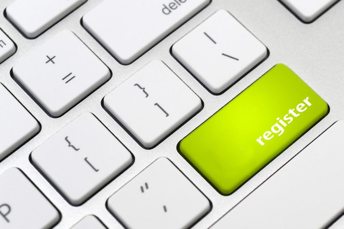 Computer keyboard with key in the color green that says "register."