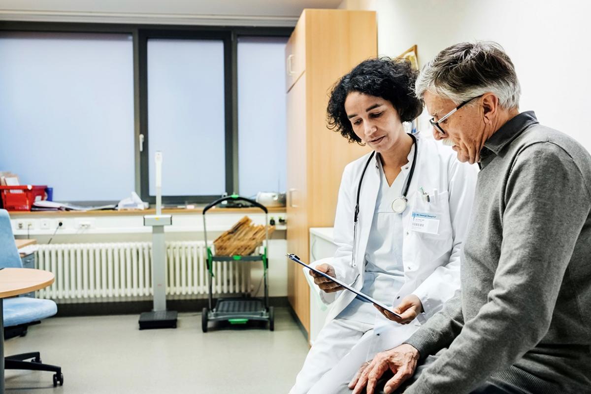 Female physician reviewing chart with patient.